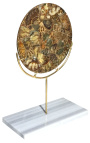 Large brown decorative disc with ammonites on a gold stand and white marble